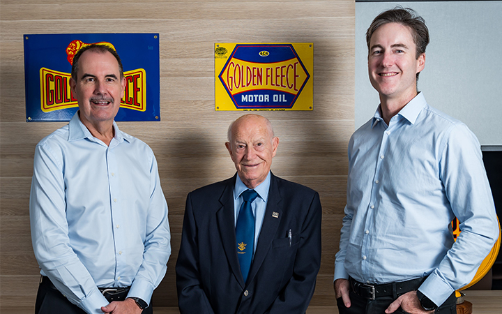 David Fraser, Frank O'Connor and Brad Gannon standing in from of Golden Fleece signage