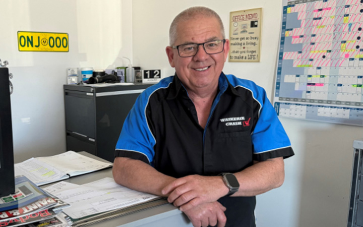 Kym, from Waikerie Crash, smiles at the camera from his office desk.