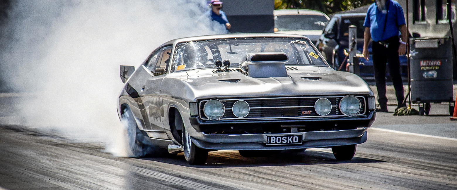 Drag car, Ford Falcon XA Coupe, billowing smoke on the track.