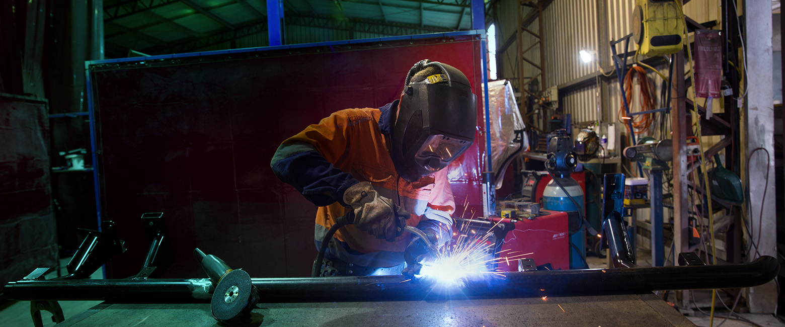 A skilled person welding in a workshop, creating sparks as they work