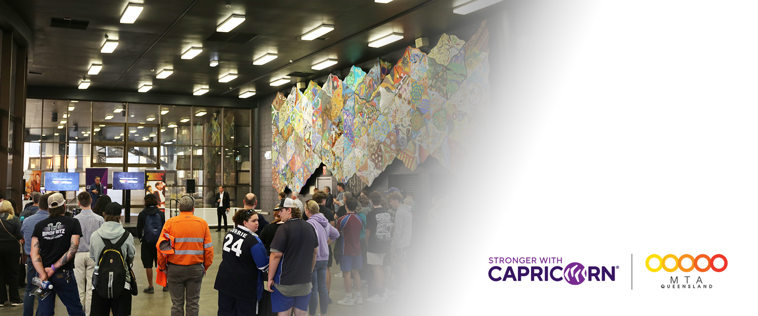 A group of youths at a career expo in Queensland, featuring Capricorn and MTAQ logos on the right side.