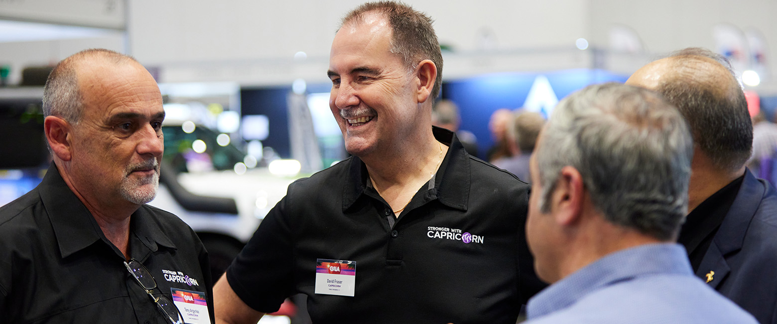 David Fraser, Capricorn Group CEO, engaging warmly with attendees at an industry event, wearing a black polo with the Capricorn logo, showcasing his approachable leadership style.